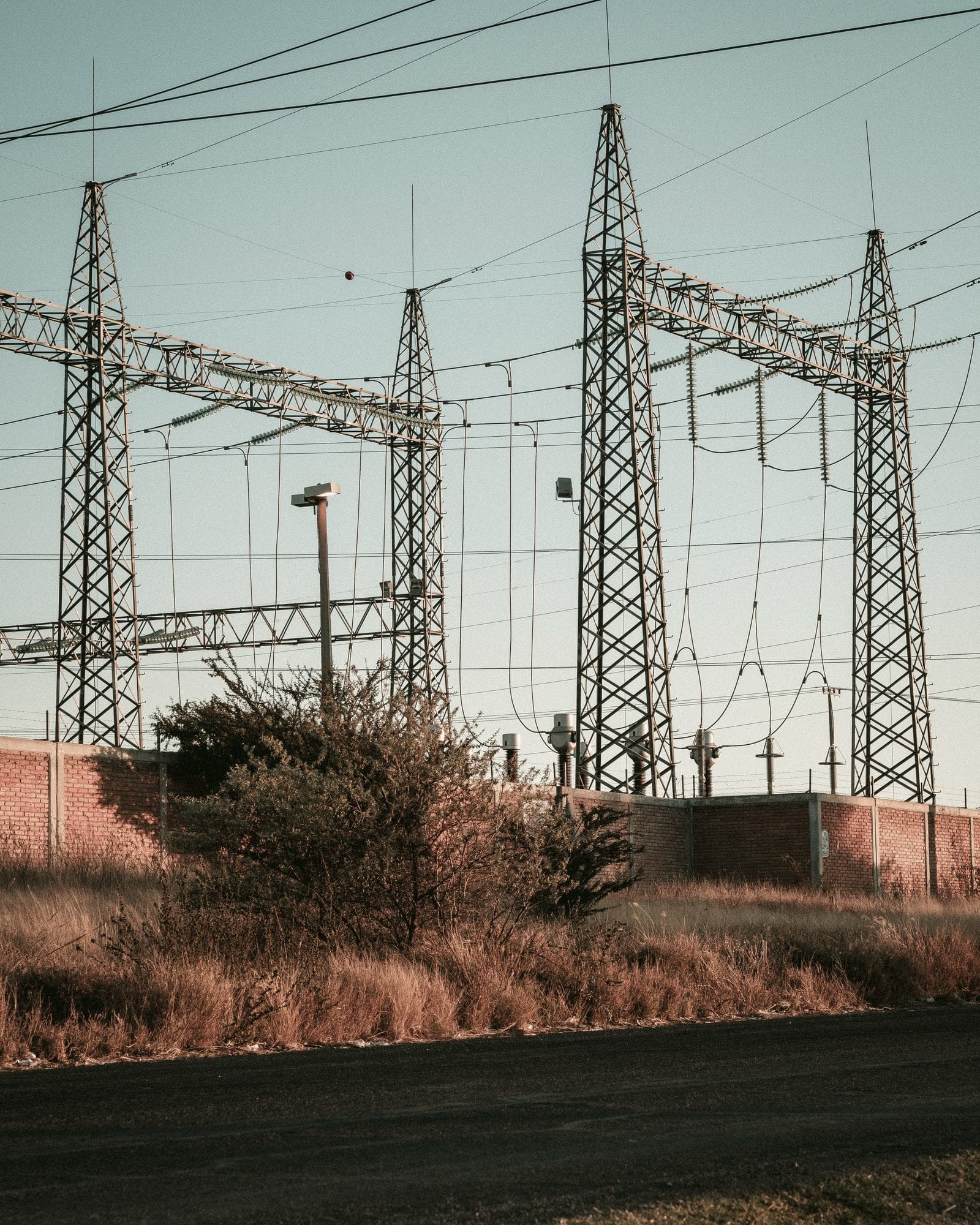 Electrical substation behind a perimeter wall.