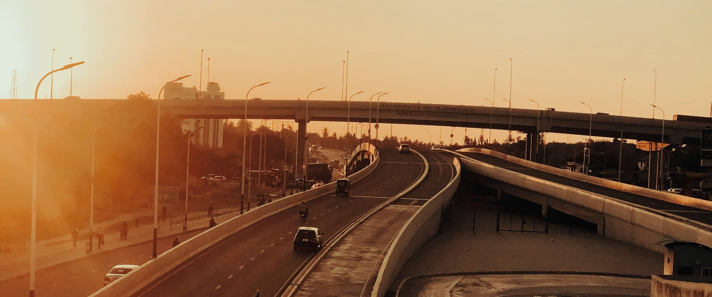 Elevated highway interchange in Dar es Salaam at golden hour — licensed photography, see credits.