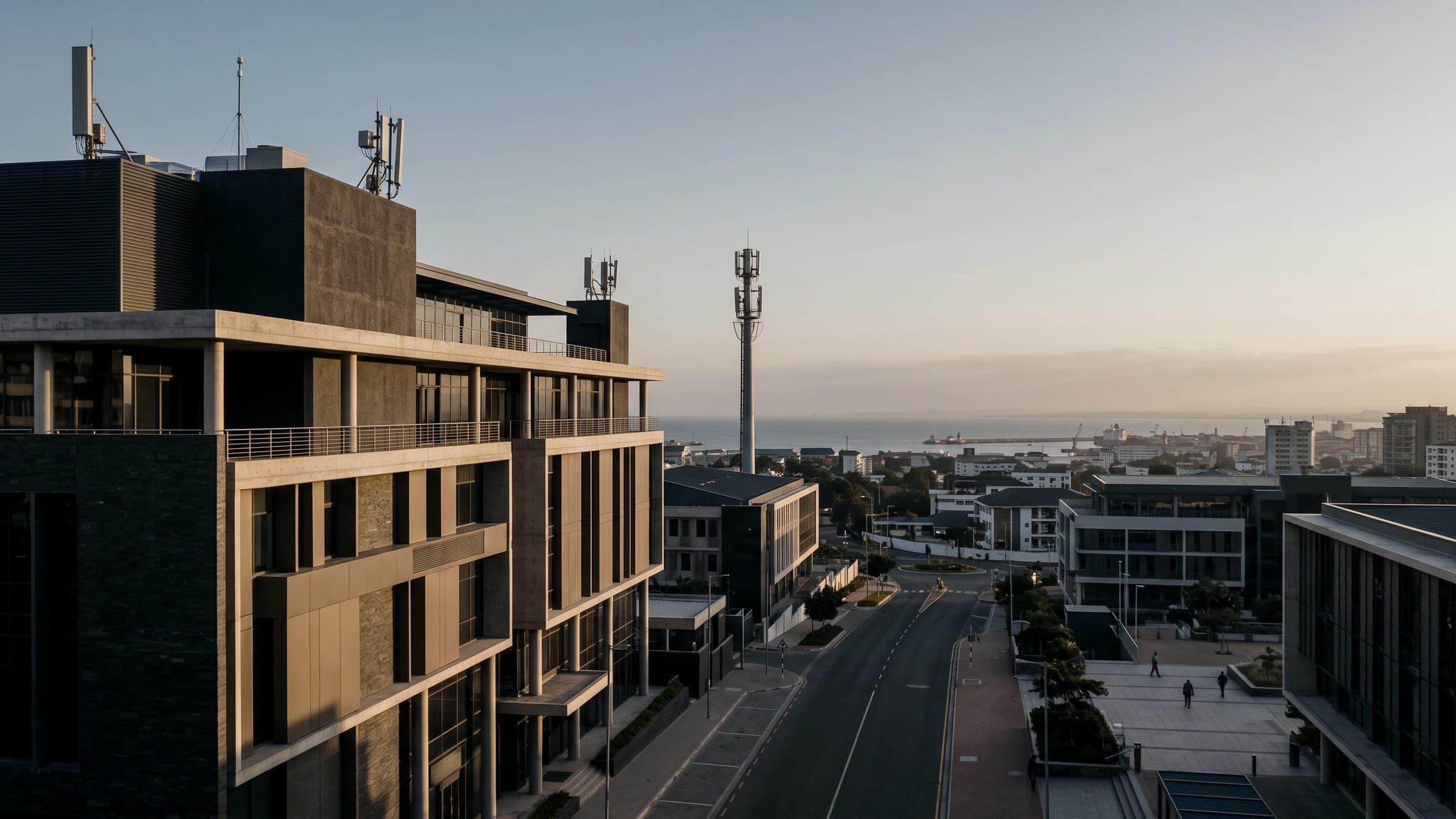 Editorial view of institutional architecture and rooftop communications infrastructure above an East African coastal city — conceptual imagery, not a documented Nextec location.